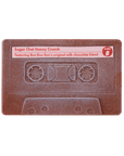 A chocolate cassette tape with 'Sugar Chai Honey Crunch' text and a note mentioning Bon Bon's original milk chocolate blend.