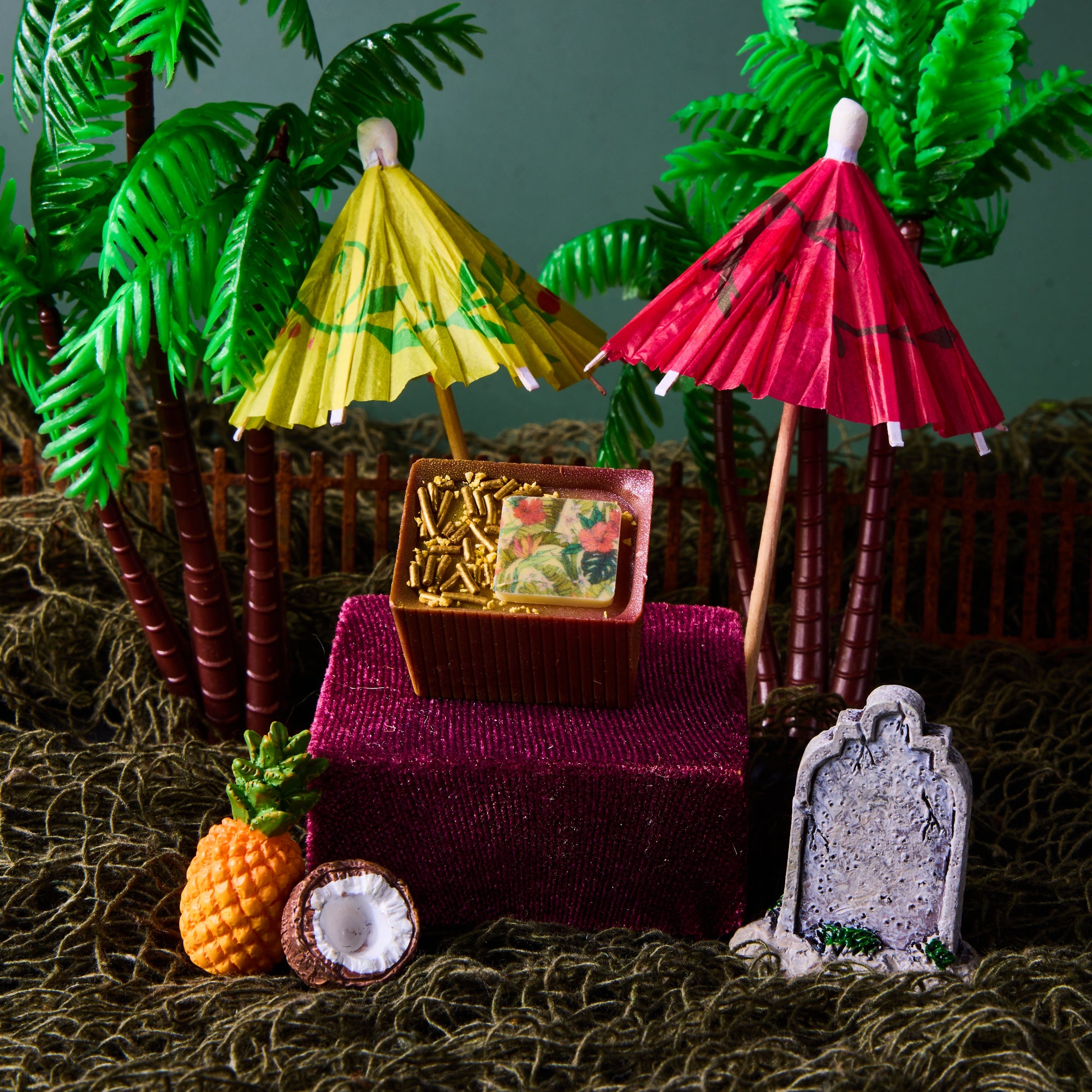 Tiki Tom Bon with cocktail umbrellas and a mini gravestone, accompanied by mini fruits 
