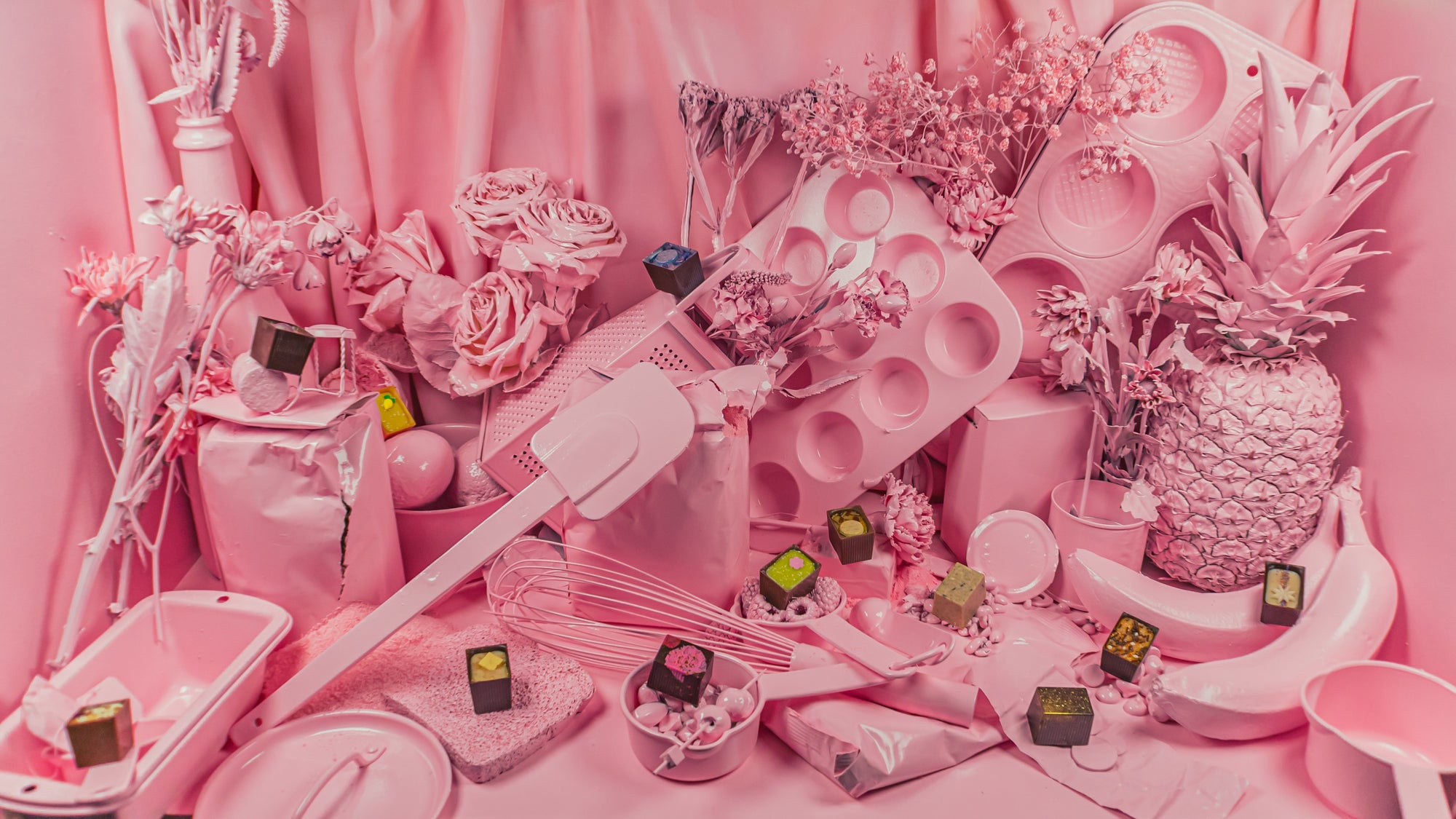 Pink spray painted baking supplies with Bons sprinkled on each item.