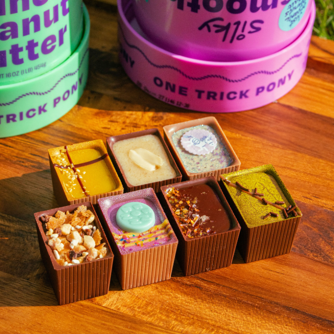 7 Bons on a wooden board with peanut butter jars in the background