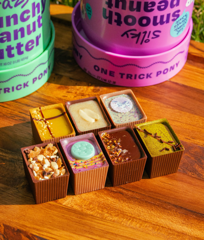 7 Bons on a wooden board with peanut butter jars in the background