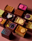 Assorted chocolate truffles with various toppings on a brown background