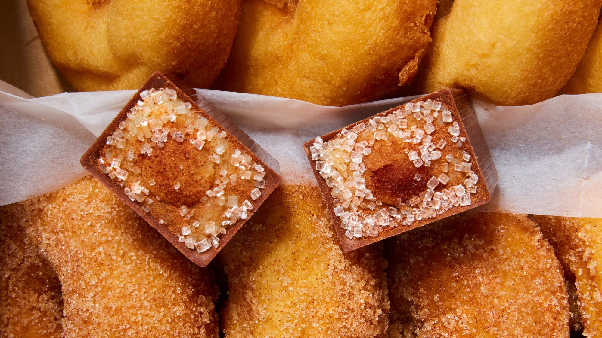 Donuts with chocolate squares on top, surrounded by more donuts.