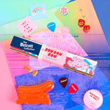 A package of Detroit-themed Bon Bon Bon candy with various flavors displayed in front, set against a colorful background featuring Detroit landmarks.
