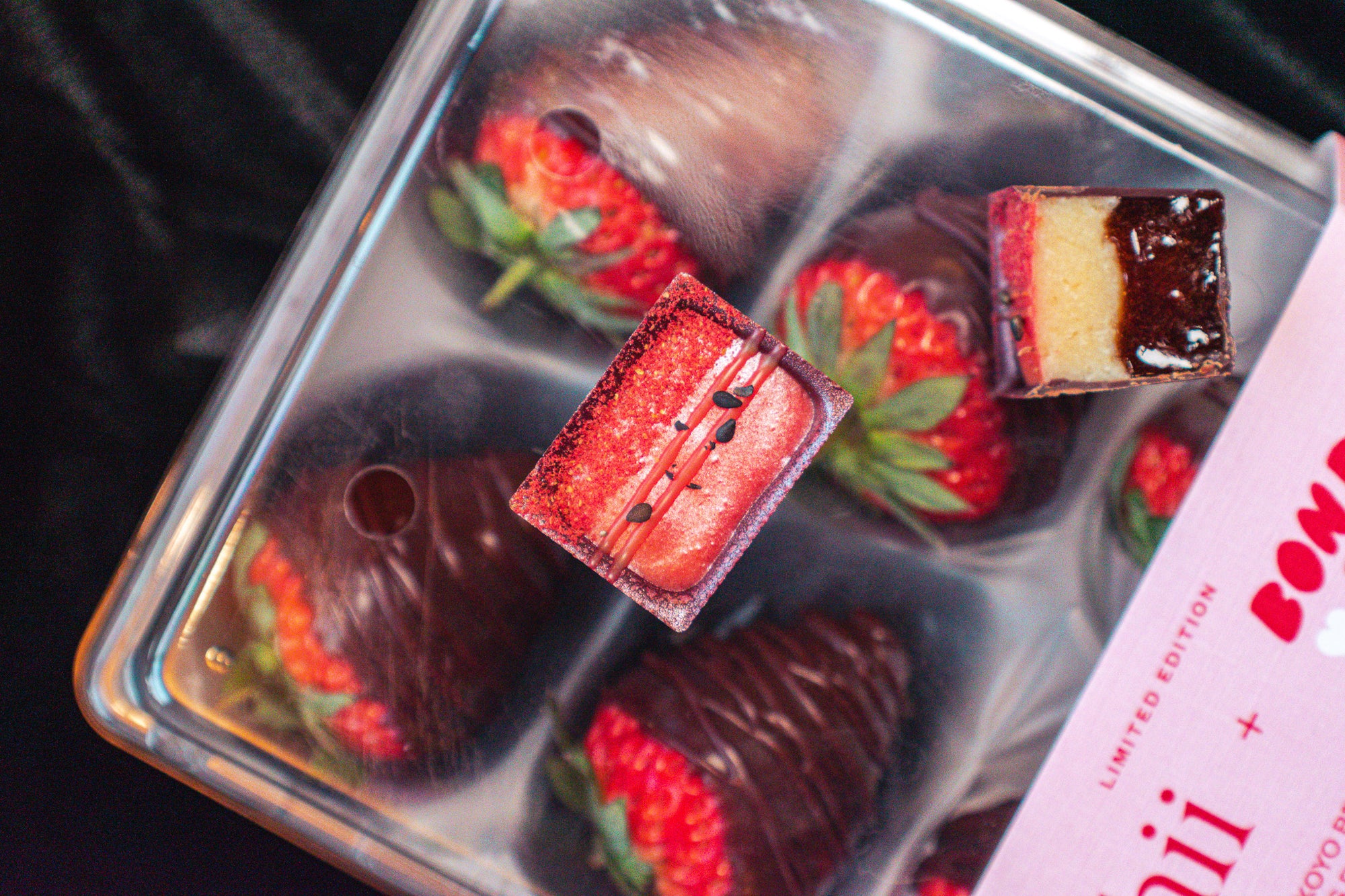 Oishii Berry Bon and Bon cross section on top of a pack of chocolate covered strawberries