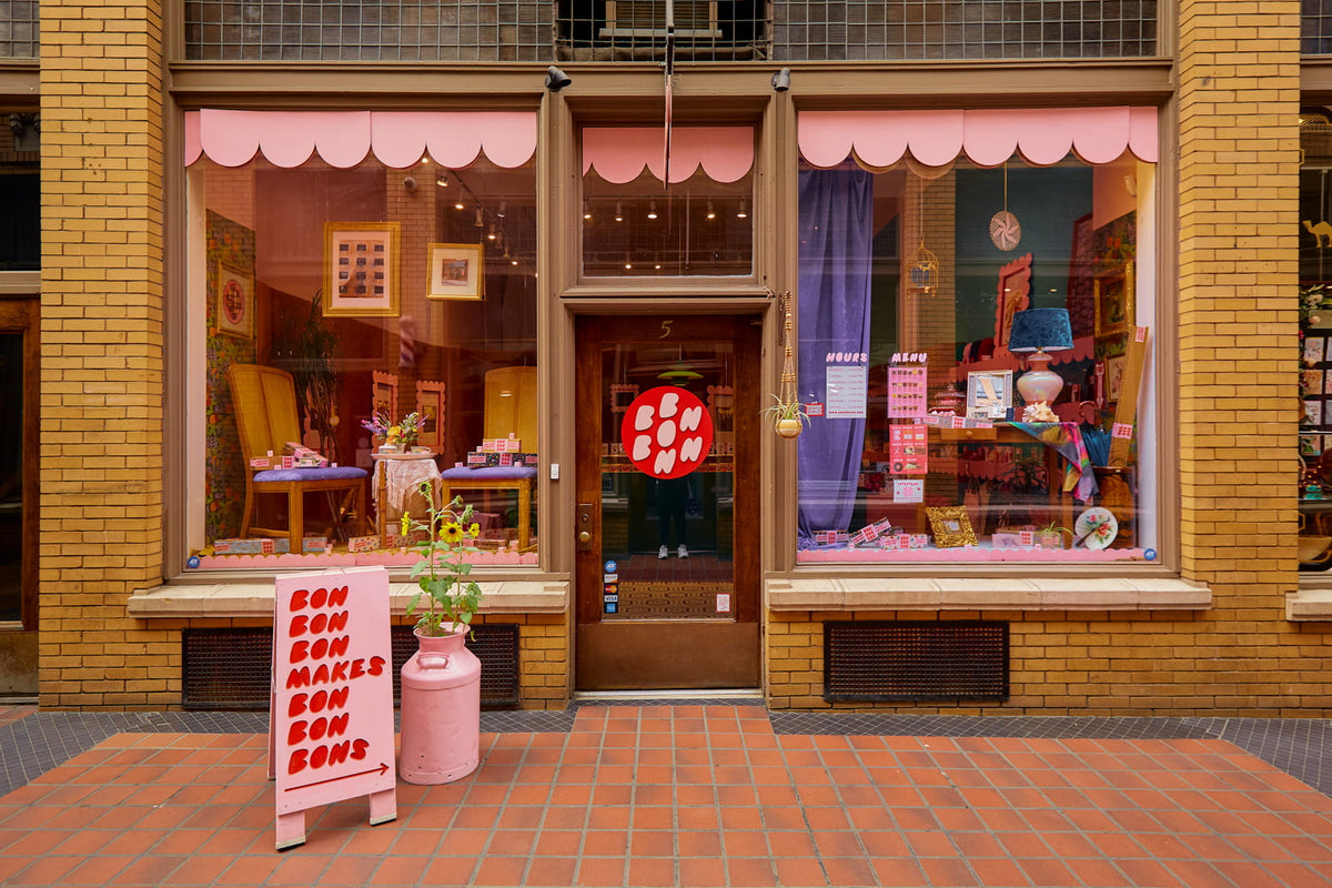 The exterior of Bon Bon Bon's shop in Ann Arbor, Michigan, with a sign out front that reads "Bon Bon Bon makes bon bon bons"
