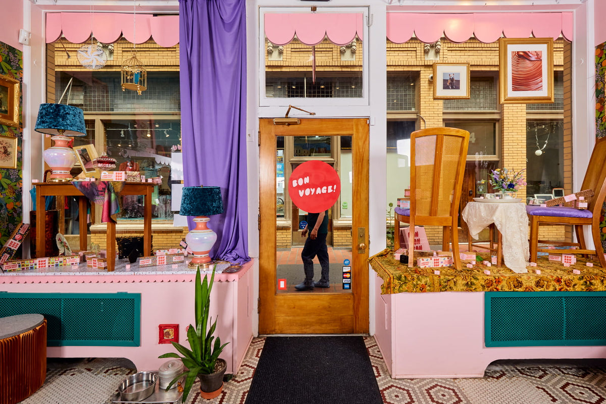 A shot of the interior of Bon Bon Bon in Ann Arbor as you're exiting into Nickel's Arcade, showing a sign on the door that says "Bon Voyage!"